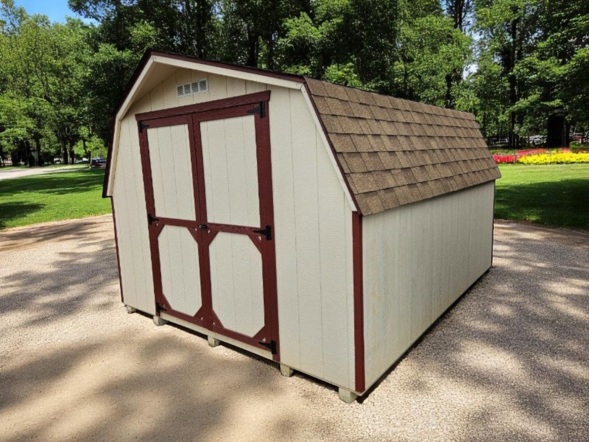 Cream Mini Barn shed with gambrel barn-style roof on green lawn